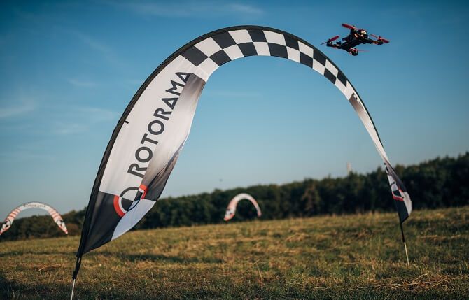 létání se závodními drony na louce