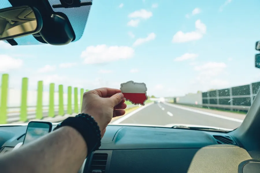 Řidič ukazuje nálepku ve tvaru a barvách Polska