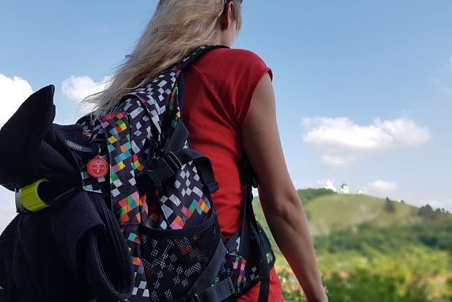 Turistka s URGENT ID na batohu.